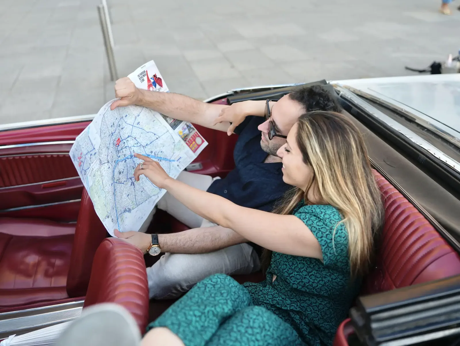 A couple sharing a Paris map in the Mustang’s red rear seats