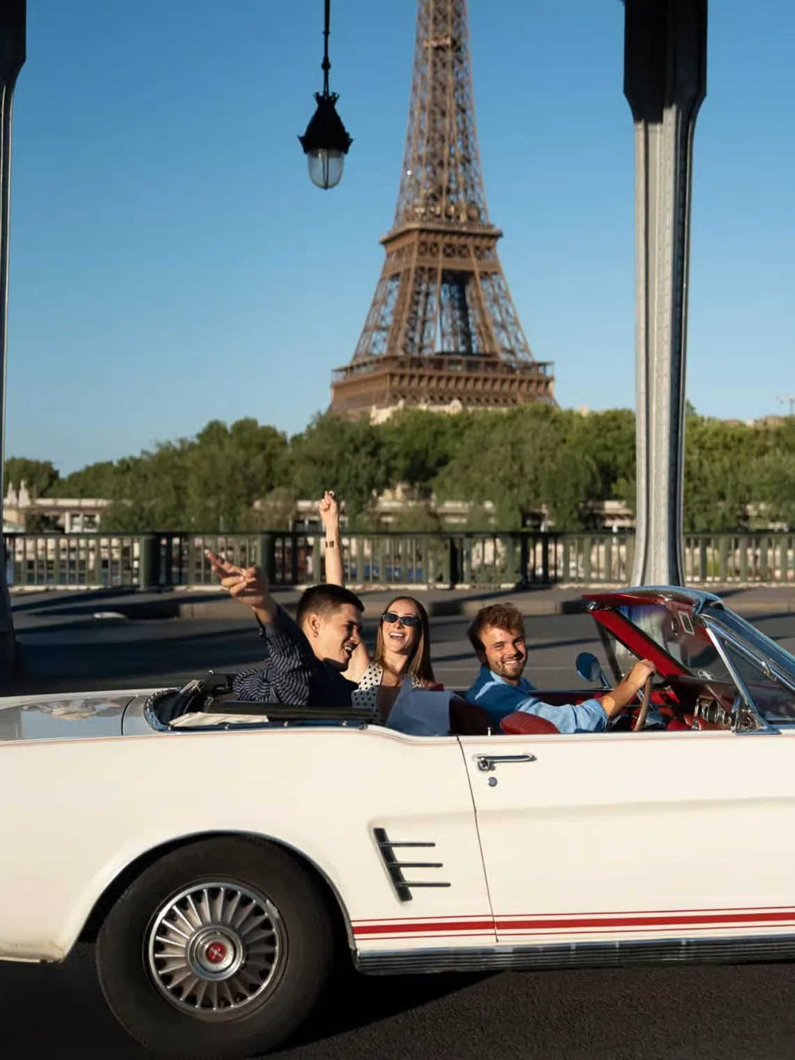 Guests enjoying a private Mustang tour beside the Eiffel Tower in Paris